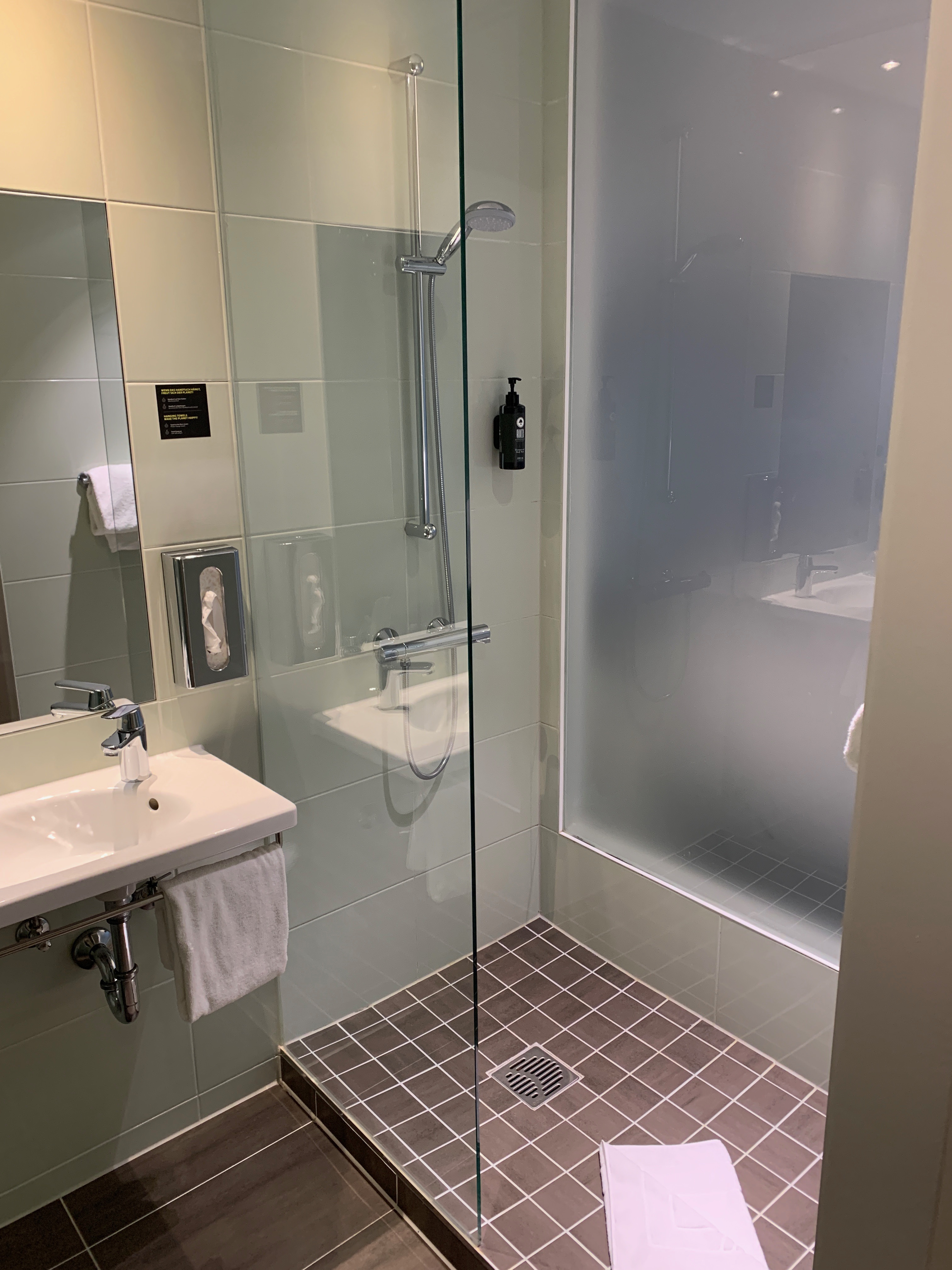 Blick in die großzügige Duschkabine und auch Waschbecken mit Spiegel